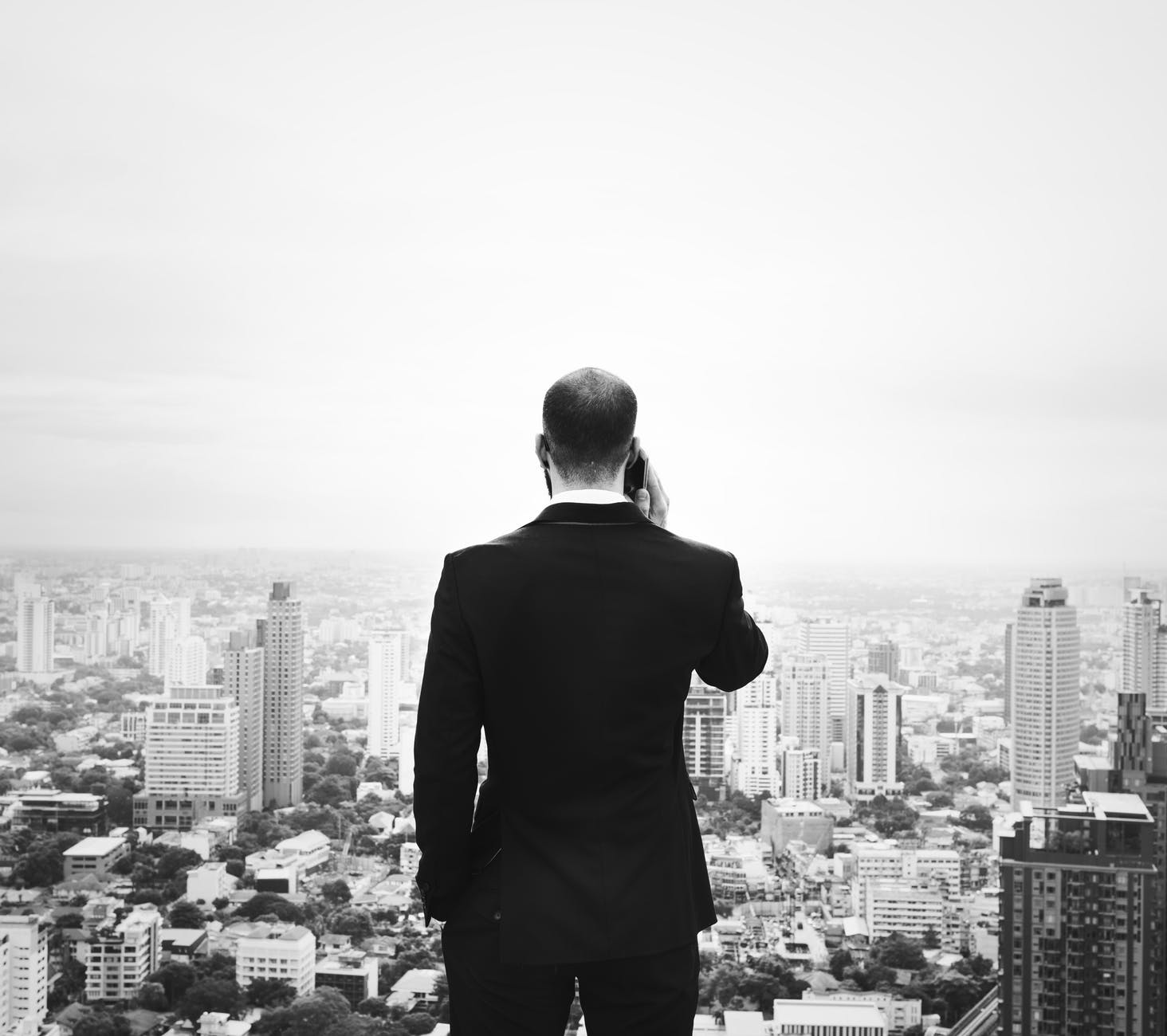 grayscale photography of man holding phone