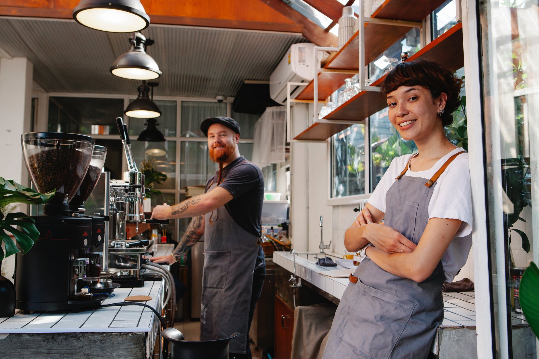happy woman baristas working in modern cafe kitchen